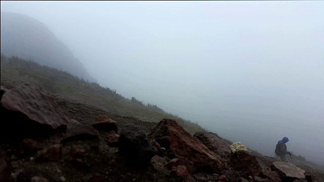 一名男子在厄瓜多尔基多皮钦查山徒步旅行，云雾缭绕，大雨倾盆视频下载