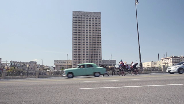 哈瓦那古巴马列孔路建立拍摄。背景是70年代的大厦和国会大厦。街道上有经典的美国老爷车，人们在墙上行走或停留。视频素材