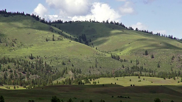 云的影子滚动在绿色的山和天空白云蓬松。视频素材