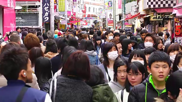 镜头穿过拥挤的竹下街。镜头捕捉了街道两侧的时尚精品店、咖啡馆和餐馆。视频素材