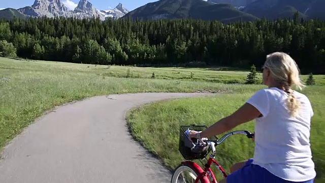 POV视角的妇女骑着巡洋车自行车在铺好的道路上视频素材