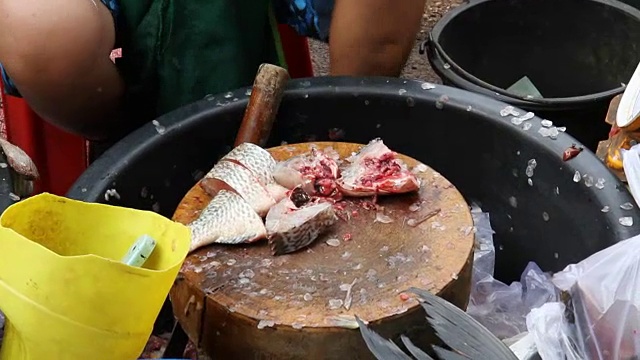 人们在当地市场切鱼出售视频素材