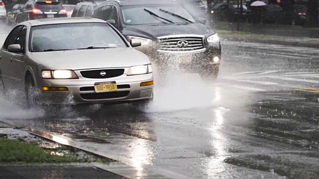 在纽约市的一场雷雨中，汽车通过水坑的慢动作。视频素材