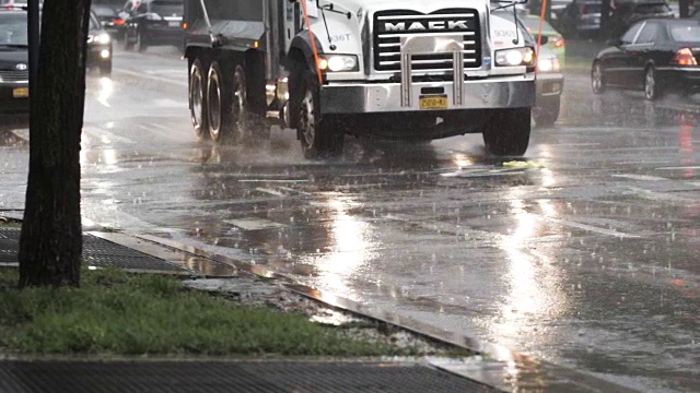 在纽约市的一场雷雨中，汽车通过水坑的慢动作。视频素材