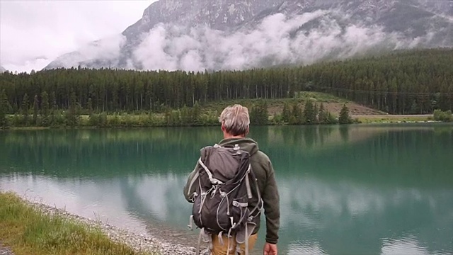 徒步者在山湖边驻足，打水漂视频素材