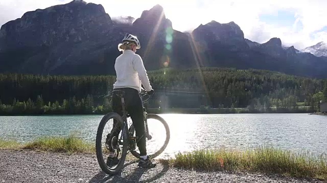 女山地自行车手在湖边的山路上停下来视频素材