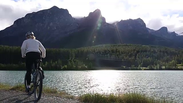 女山地自行车手在湖边的山路上停下来视频素材