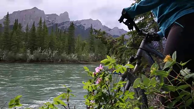 女山地自行车手到达河边，森林下面，山脉视频素材