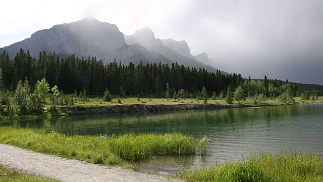 一名男性山地自行车手沿着山湖边的小路行驶视频素材