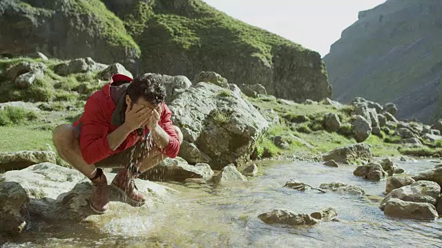 一个登山者停下来在山涧中洗澡视频素材