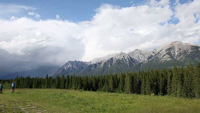 山地自行车夫妇骑越过草原山脊视频素材