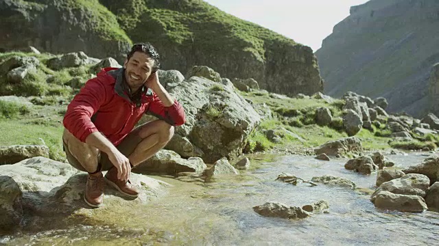 一个登山者停下来在山涧中洗澡视频素材