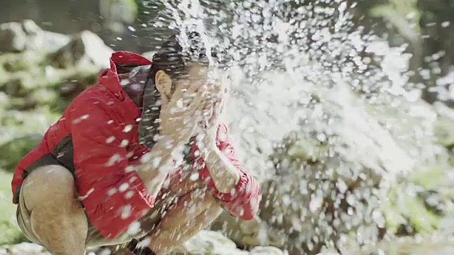 一个登山者停下来在山涧中洗澡视频素材