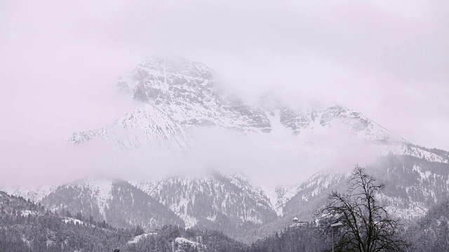 冬天，雾在雪山周围移动。视频素材