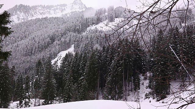 乡村雪山景观。人们在底部滑雪。视频素材