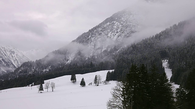 乡村雪山景观。云。在底部:不可辨认的人滑雪和椅子升降机。视频素材