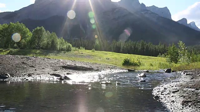 男性山地自行车骑手穿过小溪，从草地骑自行车视频素材