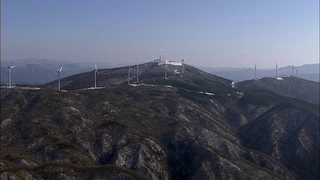 鸟瞰图上的风力发电机覆盖在雪山视频素材