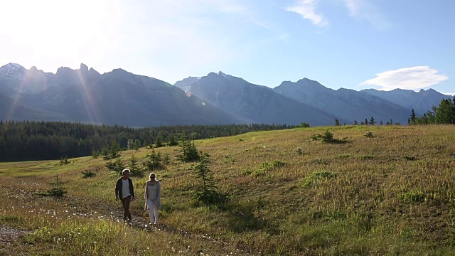 成熟的情侣走过高山草地，日出视频素材