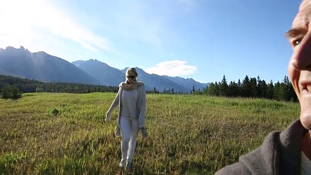 成熟的情侣走过高山草地，日出视频素材