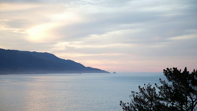 在海岸边，太阳穿过五彩缤纷的天空冉冉升起视频素材