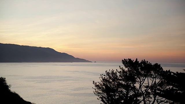 在海岸边，太阳穿过五彩缤纷的天空冉冉升起视频素材