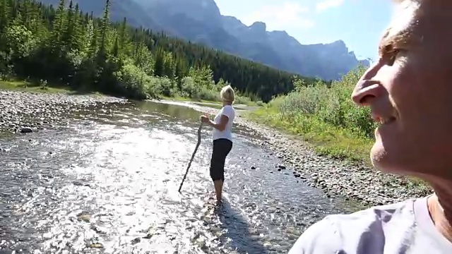 一对涉水过山涧，男人回头看女人视频素材