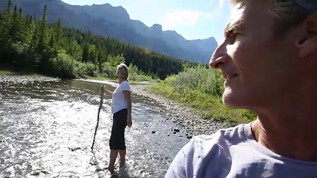 一对涉水过山涧，男人回头看女人视频素材