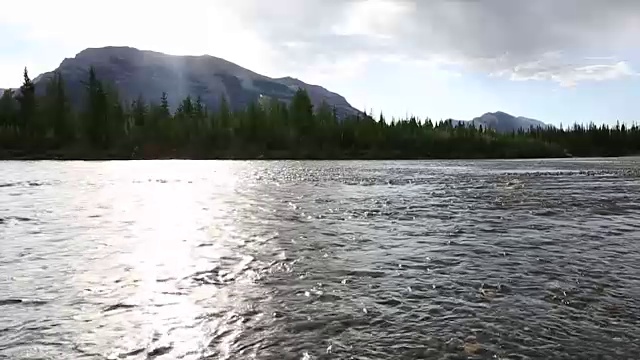 男性山地自行车骑手横渡河流向远处的山脉视频素材