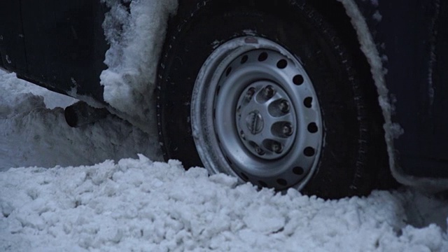 摄像头捕捉到了乔纳斯冬季暴风雪期间第六大道的交通状况。道路和汽车被雪覆盖，能见度不利于下雪。汽车轮胎在深深的雪地里打滑，汽车被卡住了。视频素材