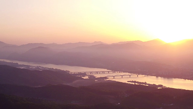 太阳在杜穆梅奥里(布汗河和南汗河的交汇处)和阳sudaegyo桥附近的山上升起视频素材