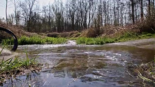 SLO MO山地摩托车漂移通过一个水坑视频素材