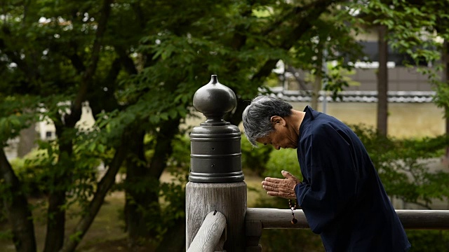 一名日本老人在寺庙里祈祷视频素材