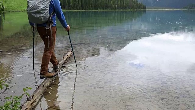 一名男性徒步者在暴风雨后探索山湖岸线视频素材