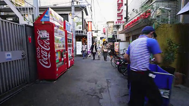 在东京神乐坂，行走的摄像机穿过神乐沟，来到道久横町狭窄的小巷。在小巷的两边有许多餐馆、酒吧和商店。视频素材