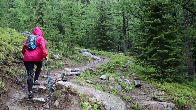 女人走在山间小路，在暴风雨中视频素材