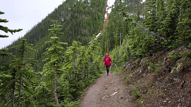 女人走在山间小路，在暴风雨中视频素材