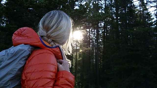 女性徒步旅行者走过日出穿过森林，清晨视频素材