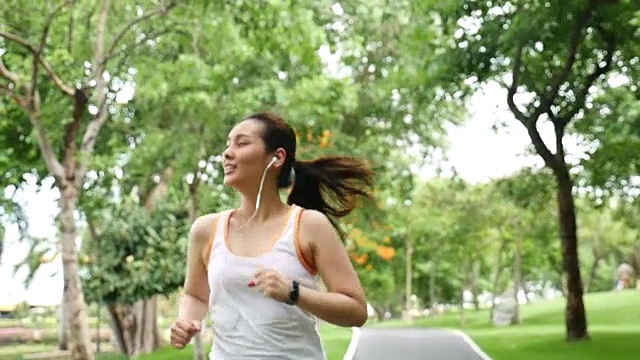 美丽的女运动员在公园跑步慢镜头视频素材