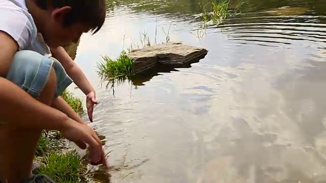 夏天的时候，两个小弟弟在加泰罗尼亚比利牛斯山脉的湖水中玩耍。视频素材