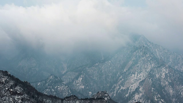 在雪覆盖的Socheongbong峰和Daecheongbong峰(雪山国家公园的最高峰)上延时流动的云视频素材