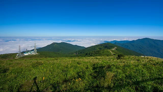 慢速拍摄微风吹在基里山国家公园(韩国著名旅游目的地)的草地上和云填充的背景视频素材