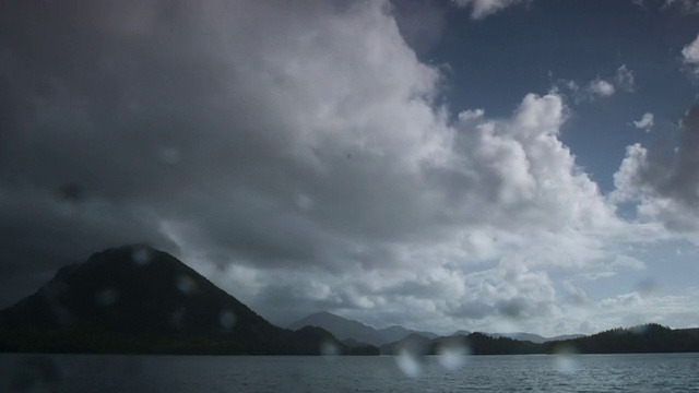 暴风云掠过多山的海岸，雨水落在镜头上。视频素材