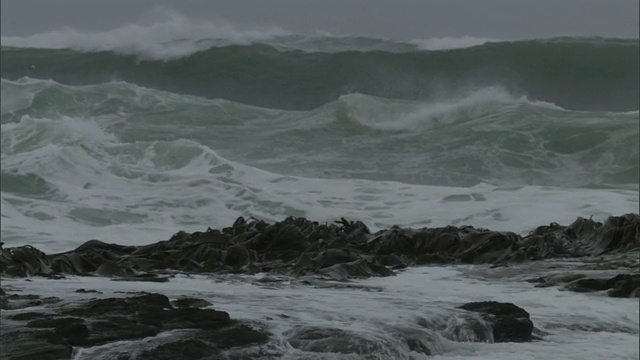 在新西兰，暴风雨的海浪翻滚到多岩石的海岸视频素材