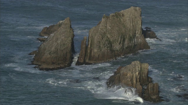 在新西兰，暴风雨的海浪卷向岩石岛屿视频素材