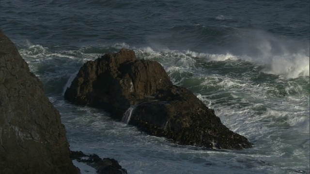 在新西兰，暴风雨的海浪卷向岩石岛屿视频素材