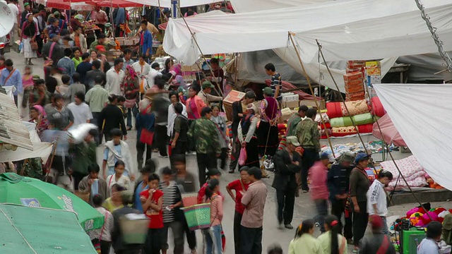 中国云南，人们川流不息地穿梭在市场的摊位间视频素材