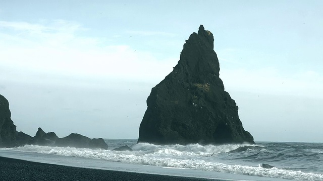 海浪翻滚到冰岛南部雷尼斯德拉加海堤附近的海滩上。视频素材