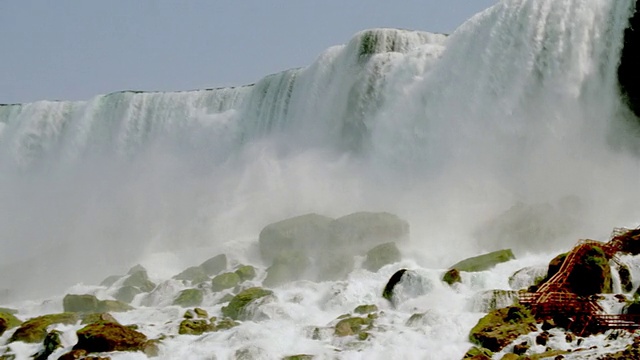 低角度PAN Niagara Falls与雾上升底部/岩石在前景视频素材