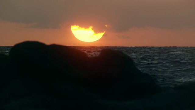 太阳在海洋上落下的缩放慢动作镜头。视频素材